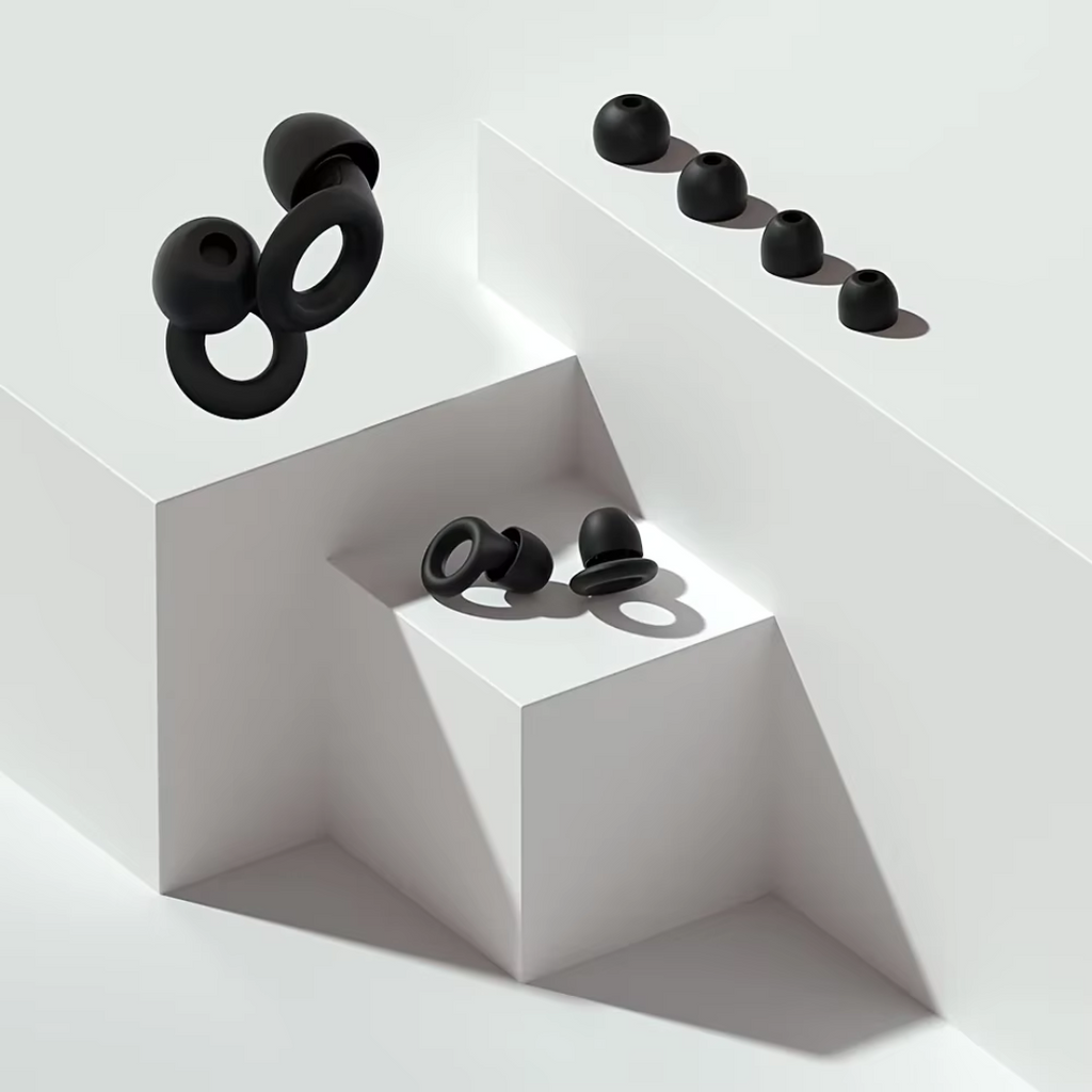 Two pairs of black earplugs with four tip sizes on blocks